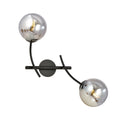 Zwarte wandlamp met twee gebogen armen en twee ronde grafietkleurige glazen kappen met zichtbare lichtbron