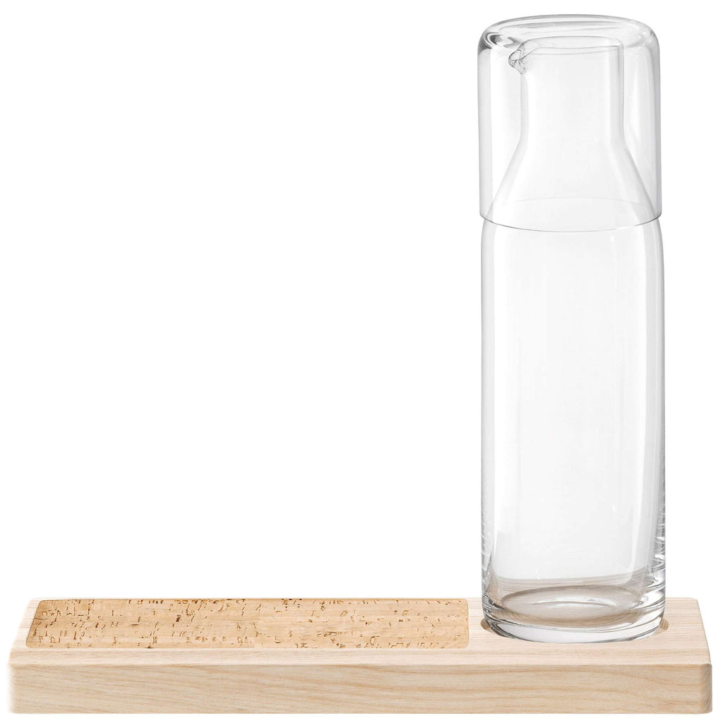 Transparante glazen karaf met glas op de hals, op een houten plateau met kurkachtige inleg