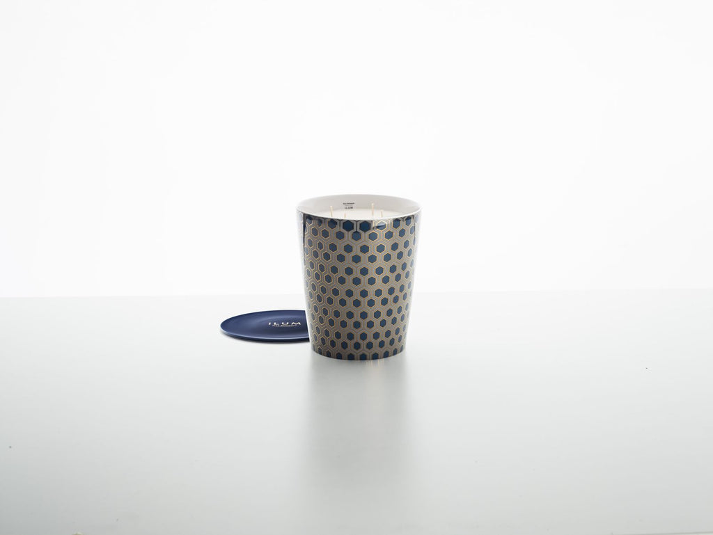 Blauwe geurkaars in retrohouder met hexagonpatroon, naast een blauw schoteltje met opdruk